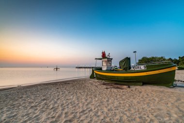Gdynia sahilinde gün doğumu ve balıkçı teknesi