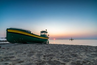 Gdynia sahilinde gün doğumu ve balıkçı teknesi