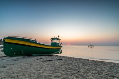 Gdynia sahilinde gün doğumu ve balıkçı teknesi
