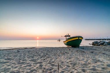 Gdynia sahilinde gün doğumu ve balıkçı teknesi