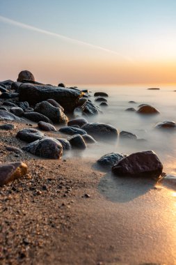 Baltık Denizi 'nin kayalık sahillerinde gün doğumu
