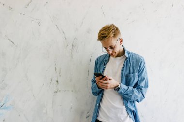 Evde elinde cep telefonu olan genç bir adam. Evdeki telefonu kullanan genç bir adamın yakın çekimi. Bir adam arkadaşlarıyla cep telefonuyla iletişim kurar. Evden çalışan genç iş adamları.