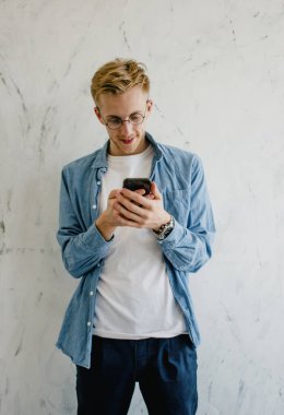 Evde elinde cep telefonu olan genç bir adam. Evdeki telefonu kullanan genç bir adamın yakın çekimi. Bir adam arkadaşlarıyla cep telefonuyla iletişim kurar. Evden çalışan genç iş adamları.