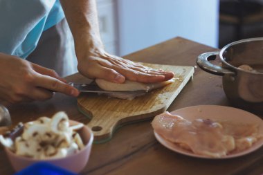 Genç bir şef mantar keser ve tavuk pişirir. Julienne pişirmek, evde et pişirmek. Yüksek kalite fotoğraf