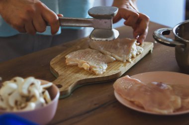 Genç bir şef mantar keser ve tavuk pişirir. Jülyen pişiriyorum.