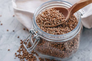 Tahta kaşıkla cam bir kavanozda karabuğday