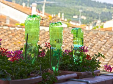 Sulama sistemi olarak balkondaki çiçekleri sulamak için plastik şişeler