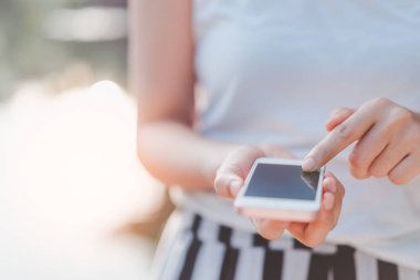 Açık hava parkının arka planında akıllı telefon kullanarak kadının elini tut. Teknoloji ve seyahat tatil konseptinin kopyalama alanı. Klasik ton filtre efekti renk biçimi.