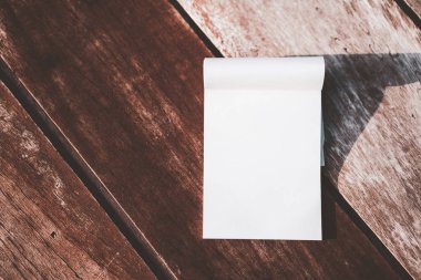 Alanı boş beyaz kağıt defter ahşap masa doku zemin üzerine kopyalayın. Planı kavramı için yaşam ve iş. Vintage sesi filtre efekti renk stili.