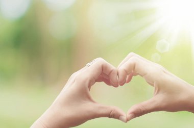 Eller şekil doğa yeşil bokeh güneş ışık parlama üzerinde kalp ve yaprak arka plan bulanıklık. Mutlu aşk ve özgürlük kavramının alanı kopyalayın. Vintage sesi filtre renk stili.