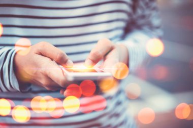 Kadın el yakından tutun park açık sokak çift pozlama renkli bokeh arka plan üzerinde akıllı telefon kullanarak. Teknoloji iş alanı kopyalayın ve tatil kavramı seyahat. Vintage sesi filtre efekti renk stili.