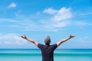 Kopyalama alanı özgürlük ve macera kavramı seyahat. Adam yükselişi el kadar plaj ve mavi gökyüzü ve bulutlar beyaz arka plan ile bir ada.