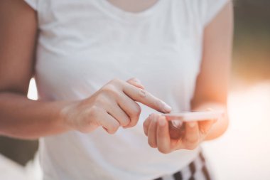 Açık hava parkının arka planında akıllı telefon kullanarak kadının elini tut. Teknoloji ve seyahat tatil konseptinin kopyalama alanı. Klasik ton filtre efekti renk biçimi.