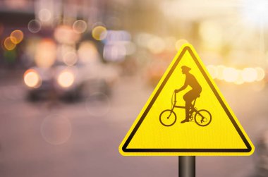 Bisiklet uyarı işareti üzerinde trafik yol ile renkli bokeh ışık arka plan bulanıklık. Ulaşım alanı kopyalayın ve kavram seyahat. Retro sesi filtre renk stili.