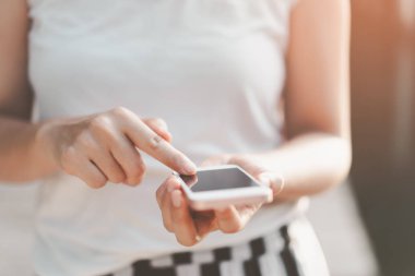 Açık hava parkının arka planında akıllı telefon kullanarak kadının elini tut. Teknoloji ve seyahat tatil konseptinin kopyalama alanı. Klasik ton filtre efekti renk biçimi.