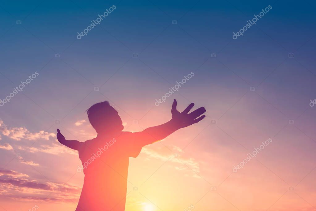 Feel good freedom and travel adventure concept. Copy space of happy man raise hands on sunset sky with sun light abstract background. Vintage tone filter effect color style.