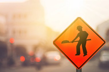 İnşaat uyarı işareti üzerinde trafik yol ile renkli bokeh ışık arka plan bulanıklık.