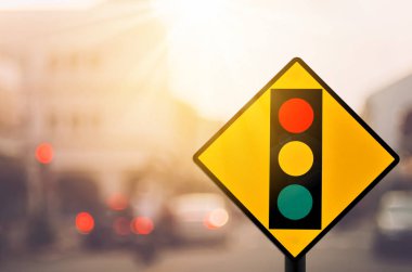 Trafik ışığı uyarı işareti üzerinde trafik yol ile renkli bokeh ışık arka plan bulanıklık.