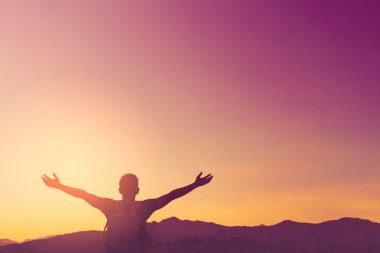 Backpacker adam altında el kadar günbatımı gökyüzü ile dağın zirvesinde yükseltmek ve arka plan bulutlar soyut.