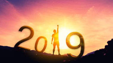 Happy new year ve tatil kavramı. Adam el üstünde tepe-in dağ ve numarası 2019 günbatımı gökyüzü ve bulut arka plan ile yetiştirme.