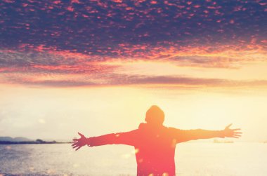 Alan adam yükselişi el üzerinde plaj ve Adası arka plan günbatımı gökyüzüne kopyalayın.