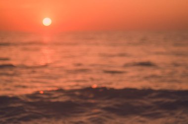 Tropikal günbatımı plaj ile bokeh güneş ışık dalga arka plan bulanıklık.