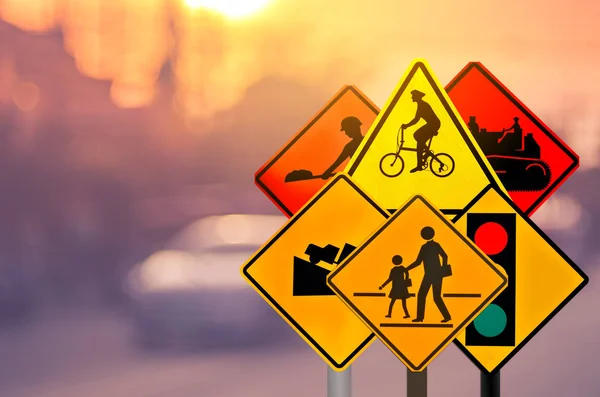 Set of traffic warning sign on blur traffic road with colorful bokeh light abstract background. — Stock Photo, Image