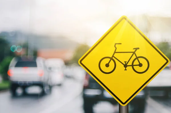 Bisiklet uyarı işareti üzerinde trafik yol ile renkli bokeh ışık arka plan bulanıklık. — Stok fotoğraf