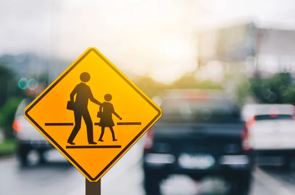 School zone warning sign on blur traffic road with colorful bokeh light abstract background. — Stock Photo, Image