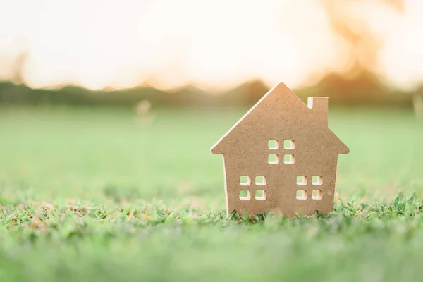 Skopiuj przestrzeni domu i życia koncepcji. Mały model domu na zielonej trawie z streszczenie tło światło słoneczne. — Zdjęcie stockowe