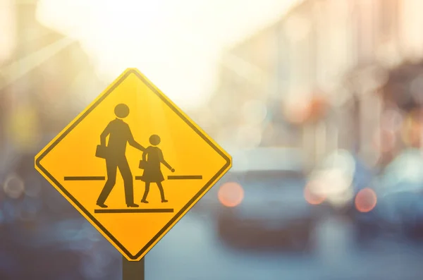 Okul bölge uyarı işareti ile renkli bokeh ışık arka plan bulanıklık trafik yolda.