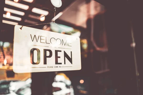 Open sign hanging front of cafe with colorful bokeh light abstract background.