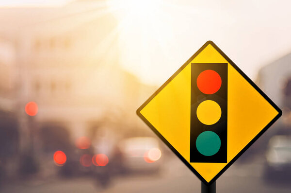 Traffic light warning sign on blur traffic road with colorful bokeh light abstract background.