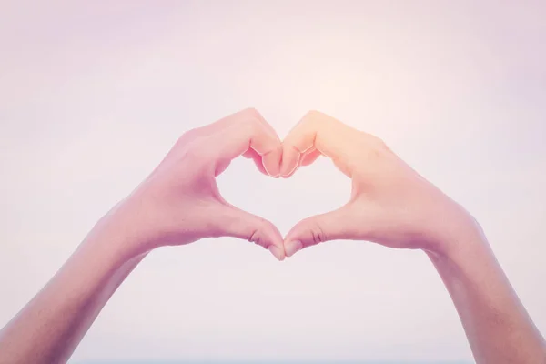 Mani femminili a forma di cuore sul cielo . — Foto Stock