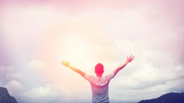 Sinta-se bem liberdade e viajar conceito de aventura. Espaço de cópia do homem feliz levantar as mãos no topo da montanha com luz do sol fundo abstrato . — Fotografia de Stock