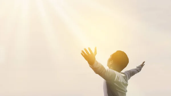 Copy space of happy man raise hands on  sky white cloud with sun light abstract background.