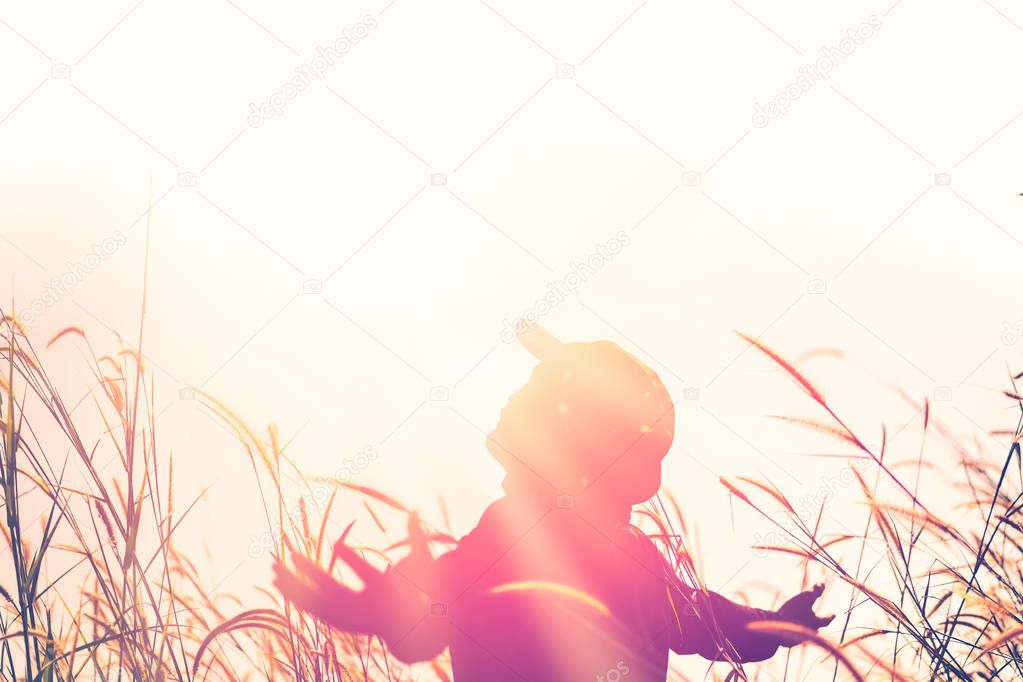 Copy space of man raise hand up on sunset sky and grass flower abstract background. 