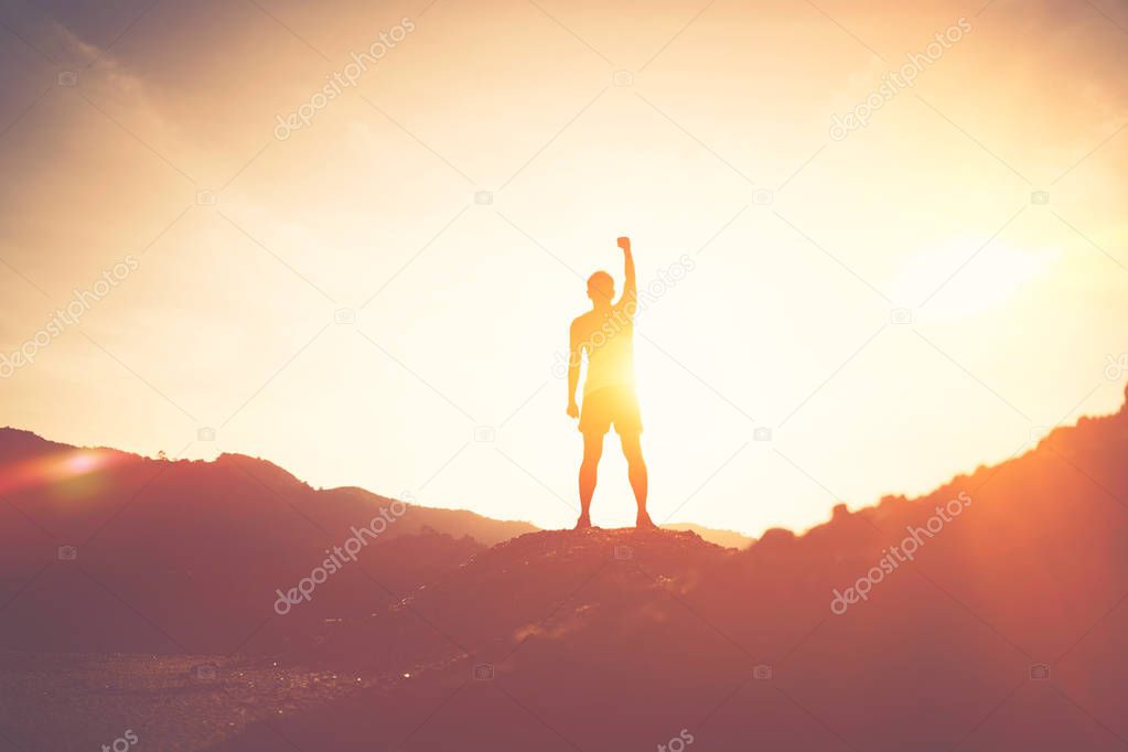 Copy space of man rise hand up on top of mountain and sunset sky abstract background.