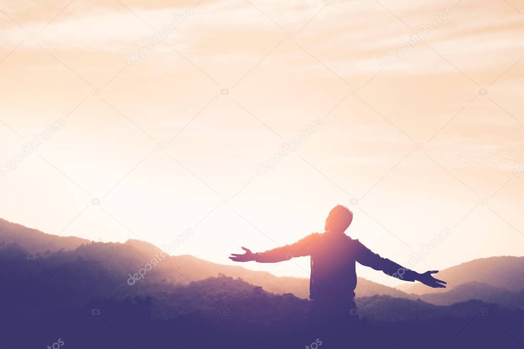 Copy space of man rise hand up on top of mountain and sunset sky abstract background.