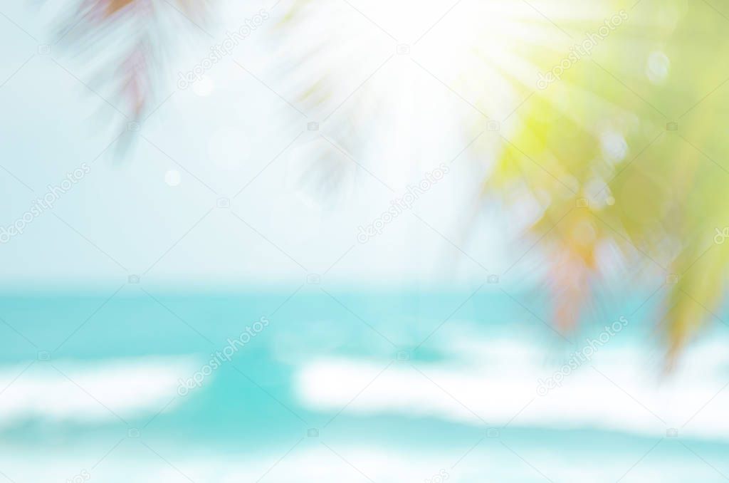 Blur beautiful nature green palm leaf on tropical beach with bokeh sun light wave abstract background.