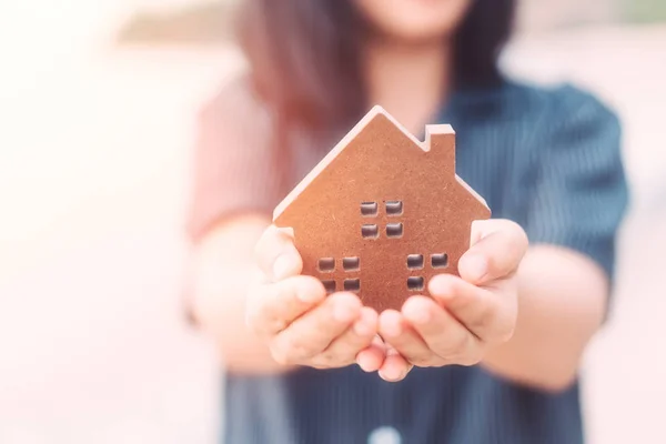 Small home model on woman hand.