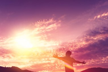 Backpacker adam altında el kadar günbatımı gökyüzü ile dağın zirvesinde yükseltmek ve arka plan bulutlar soyut.