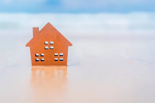 Kis otthoni modell homokos strand, kék ég háttér. — Stock Fotó