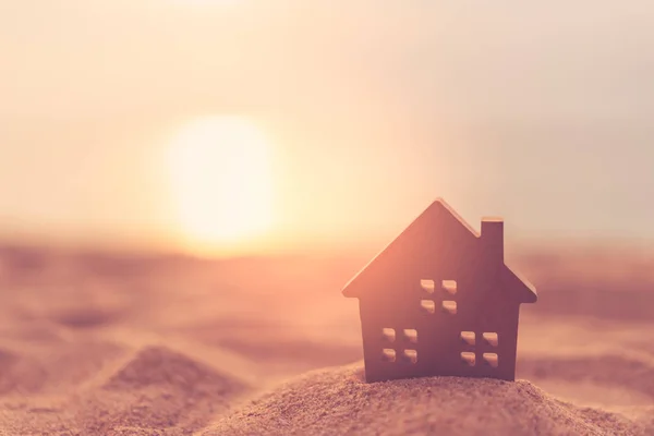 Malý model domů na plážové pláži písek pozadí textury. — Stock fotografie