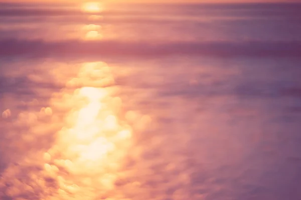 Copy space of soft sand sea and blur tropical beach with sunset sky and cloud abstract background.