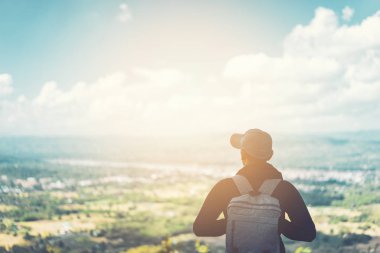 Backpacker adam mavi gökyüzü beyaz bulut soyut arka plan ile manzara görünümlü dağ tepesinde duran. 