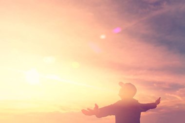 Gün batımı gökyüzü ve bulutlar soyut arka plan üzerinde ellerini yükselen siluet adam kopya alanı.