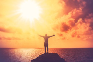 Tropik plaj ve günbatımı gökyüzü soyut arka plan üst dağda yükseltmek mutlu adam el kopya alanı.