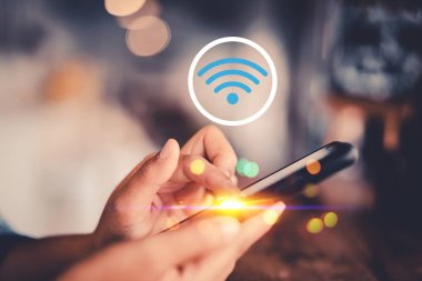 Renkli bokeh ışık ile kafede wifi simgesi soyut arka plan ile akıllı telefon kullanarak kadın el. Teknoloji iş ve modern yaşam tarzı kavramı. 