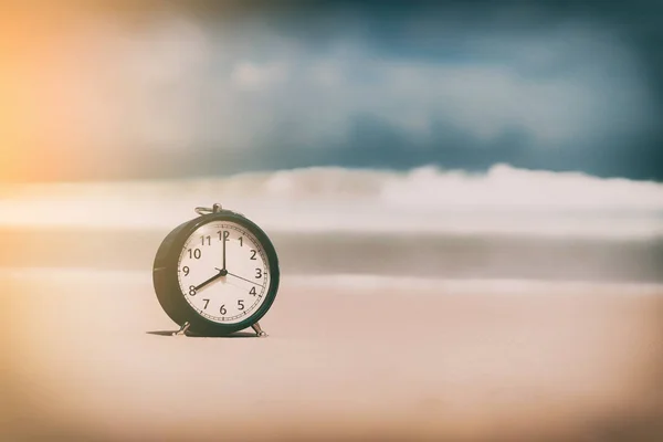 Relógio na praia de areia com fundo de onda suave . — Fotografia de Stock